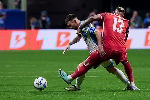 Lionel Messi and Derek Cornelius battle for the ball